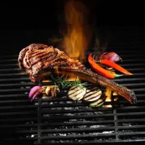 A grill with meat and vegetables on it.