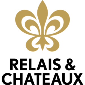 A gold fleur de lis with the words relais & chateaux underneath.